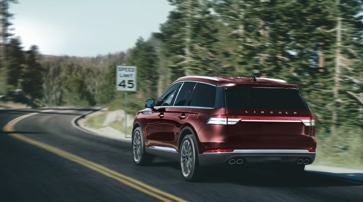 A 2024 Lincoln Aviator® SUV is being driven on a winding mountain road | Lincoln Demo 5 in Derwood MD