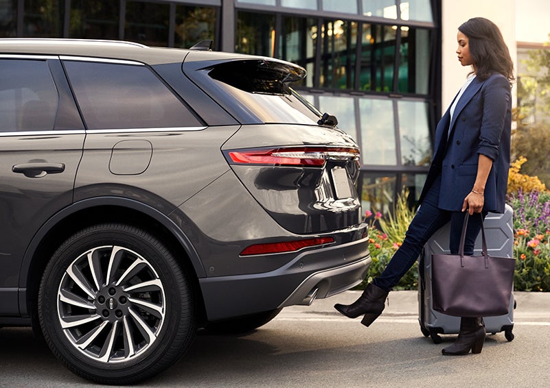 A woman with her hands full uses her foot to activate the available hands-free liftgate. | Lincoln Demo 5 in Derwood MD