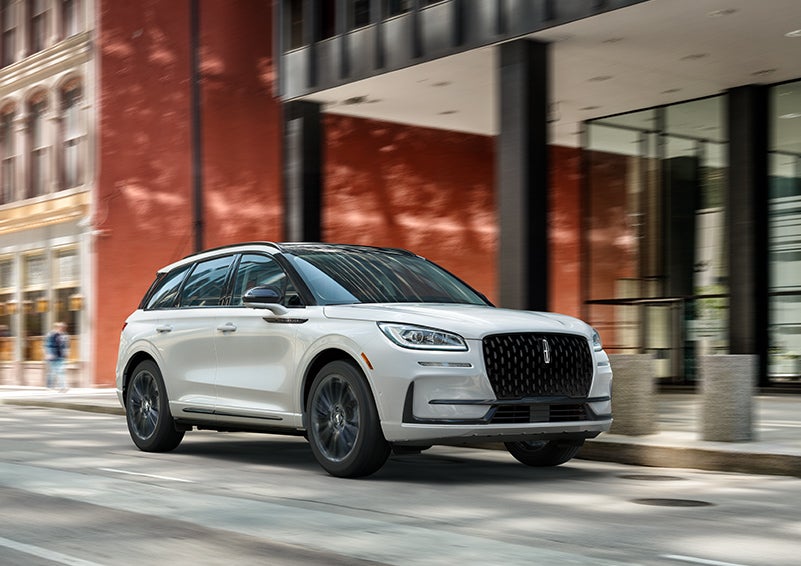 The 2024 Lincoln Corsair® SUV with the Jet Appearance Package and a Pristine White exterior is parked on a city street. | Lincoln Demo 5 in Derwood MD